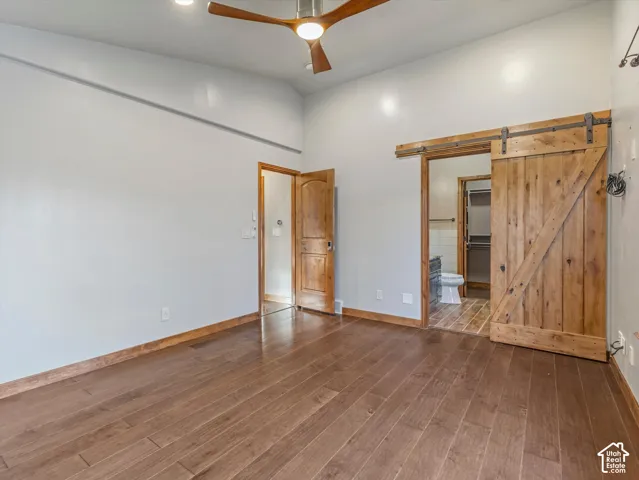High ceilings with recessed lighting, a ceiling fan, and wood-finish flooring