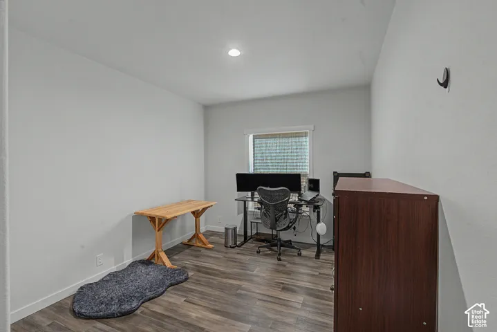 Recessed ceiling lighting, durable wood-finish flooring, and a window with horizontal blinds