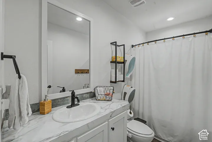 Bathroom featuring a white vanity with a marble-look countertop, an oval sink, and a black faucet