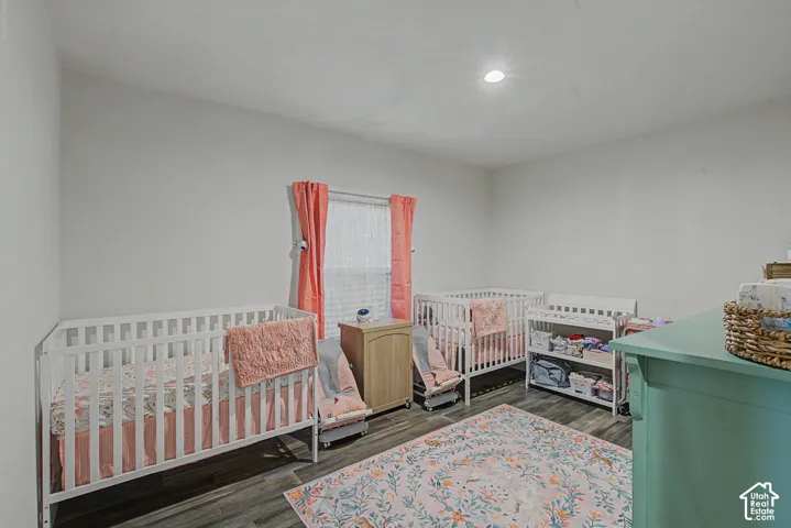White walls with recessed lighting and wood-finish flooring