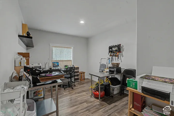 Recessed lighting, wood-finish flooring, and a single window with blinds