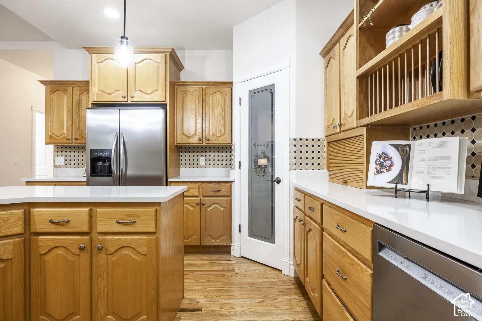 Kitchen with wood cabinetry, light countertops, and a tile backsplash