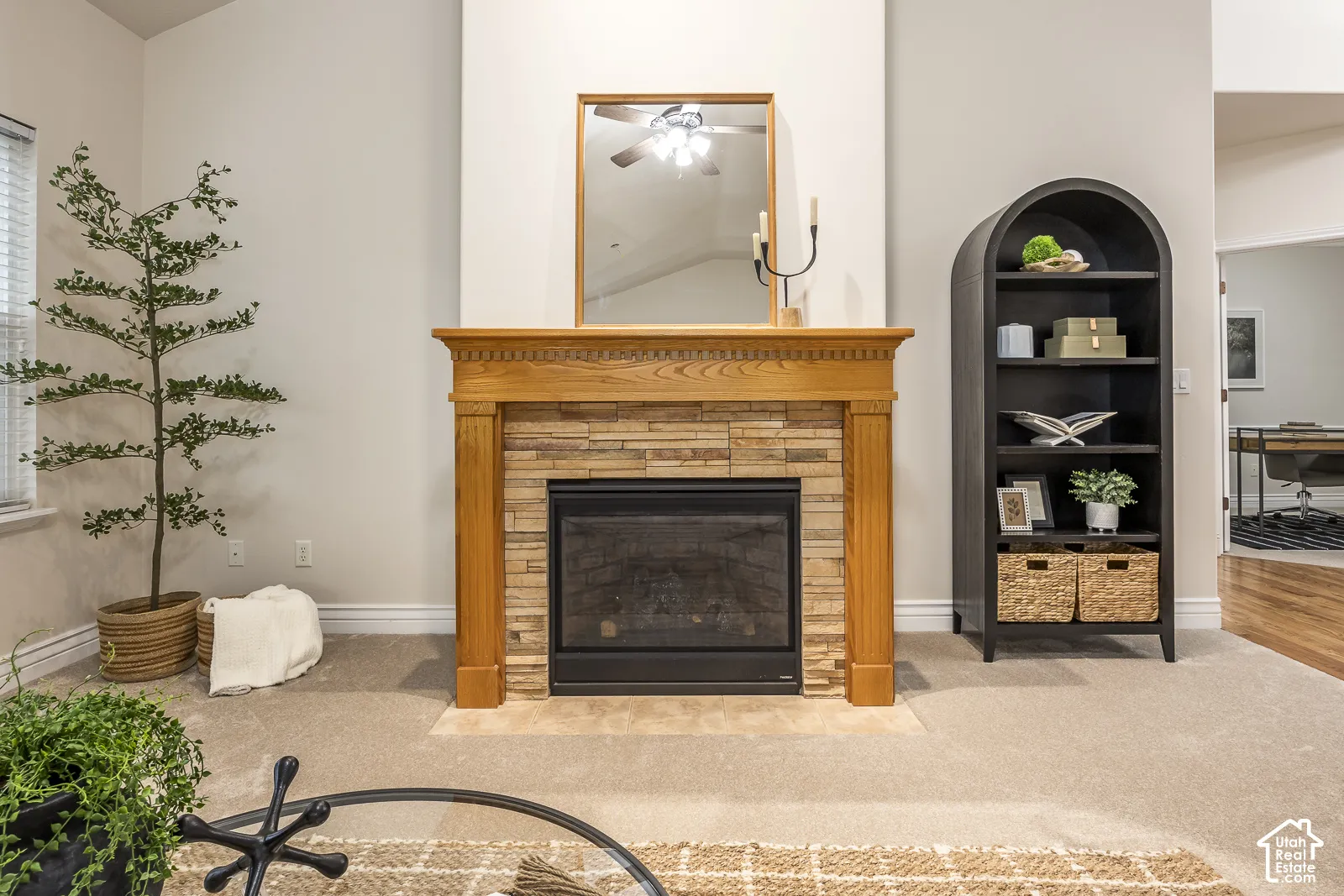Built-in fireplace with a stacked stone surround and a carved wood mantel