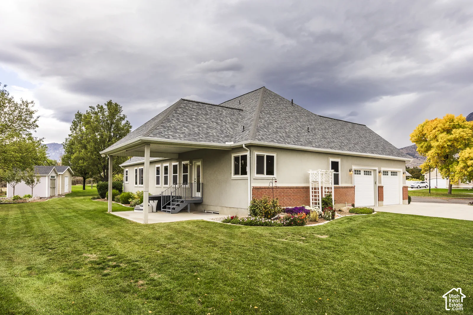 Expansive rear yard with a covered patio and concrete steps