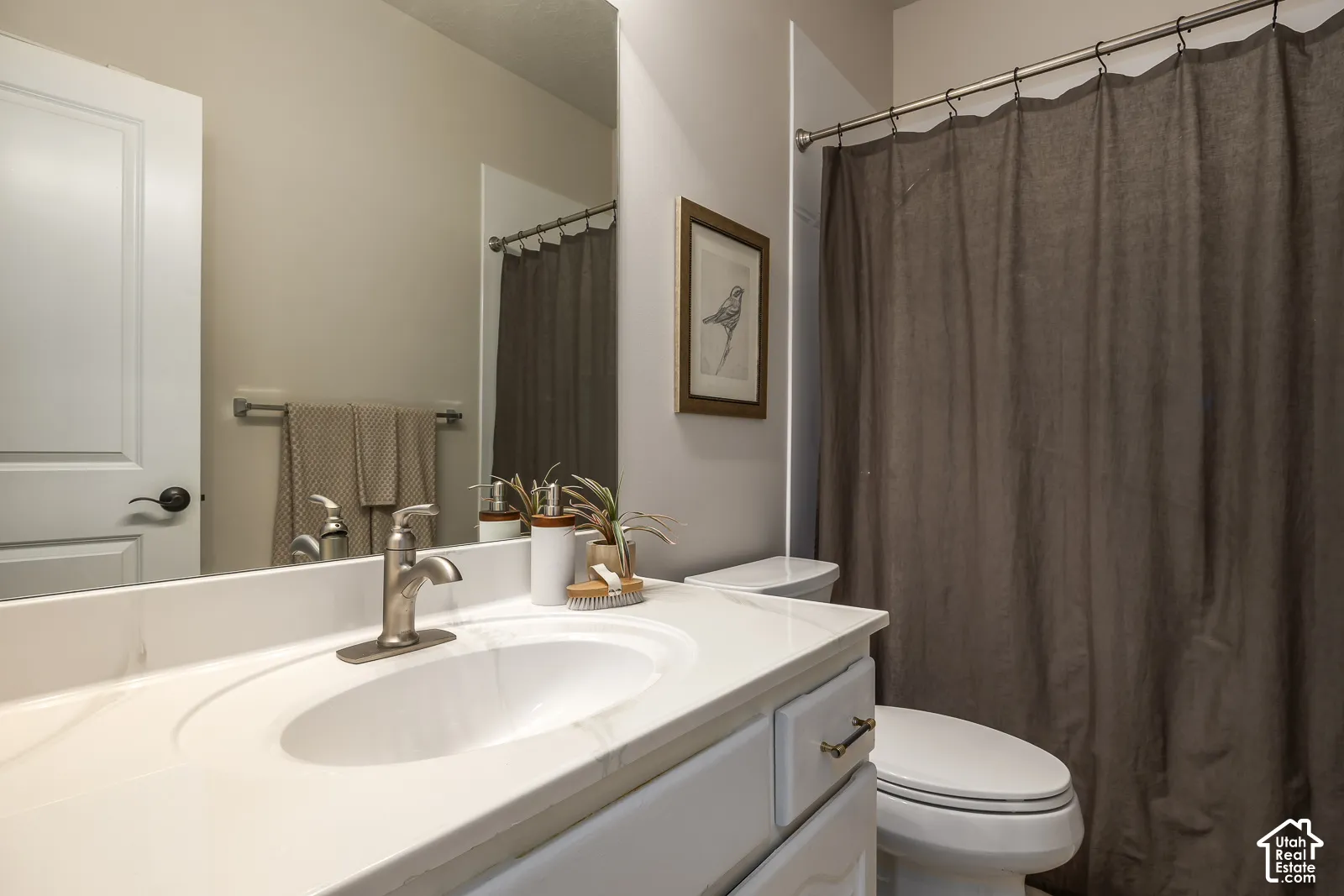 White vanity with brass-toned hardware, an integrated sink, and a brushed nickel faucet