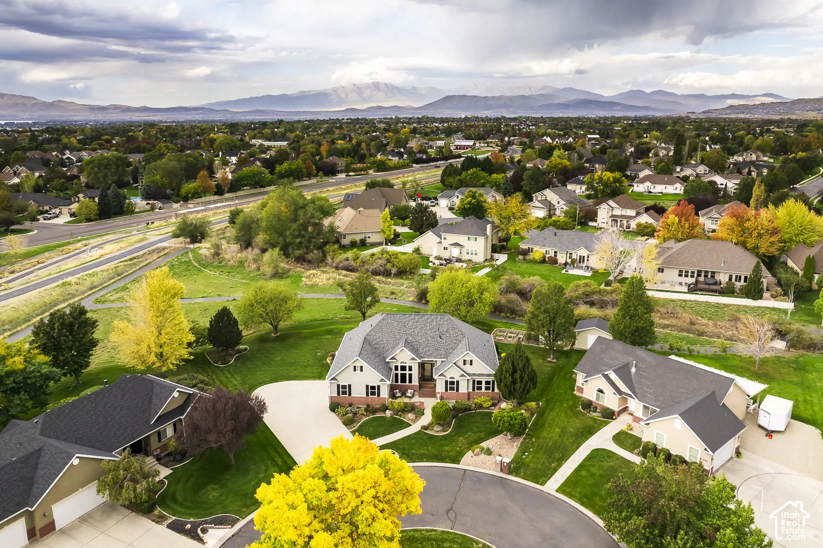 Expansive residential area with mature landscaping, mountainous backdrop, and established street infrastructure