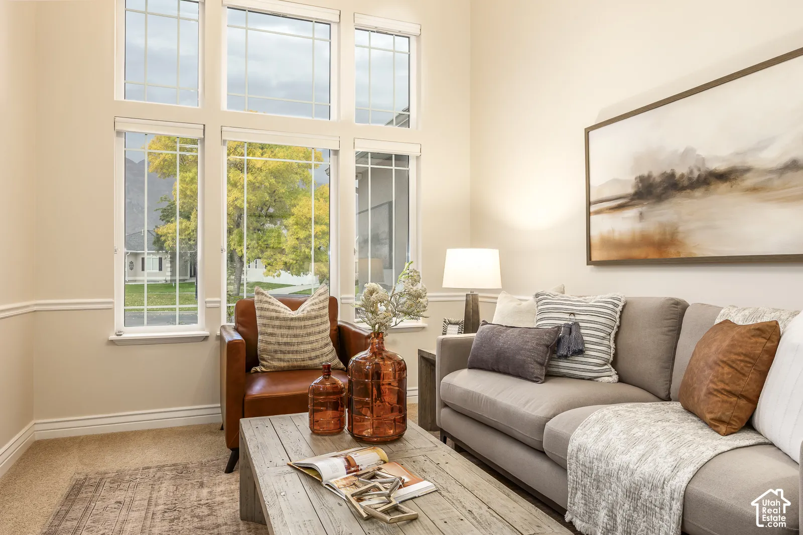 Vaulted ceiling with extensive window features, neutral wall tones, and carpet flooring