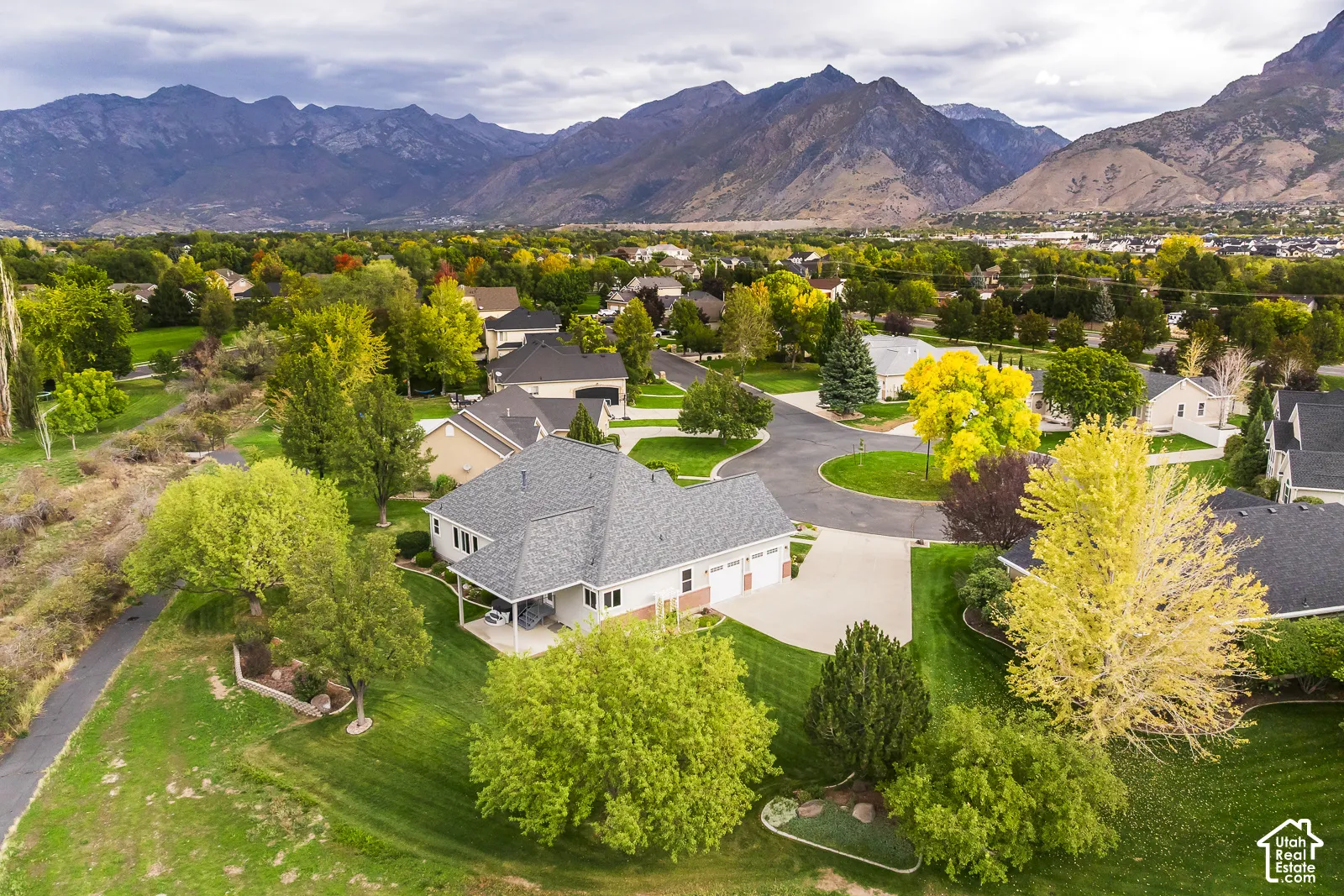 Mountain backdrop, cul-de-sac location, manicured landscaping, paved driveway, covered patio