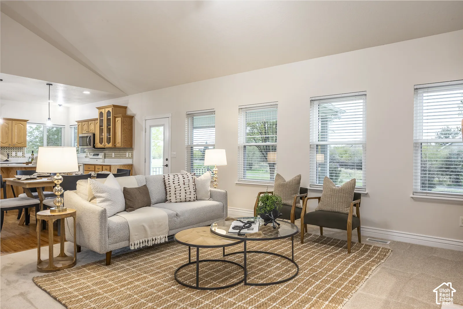 Vaulted ceilings enhance the living space, complemented by multiple windows with blinds