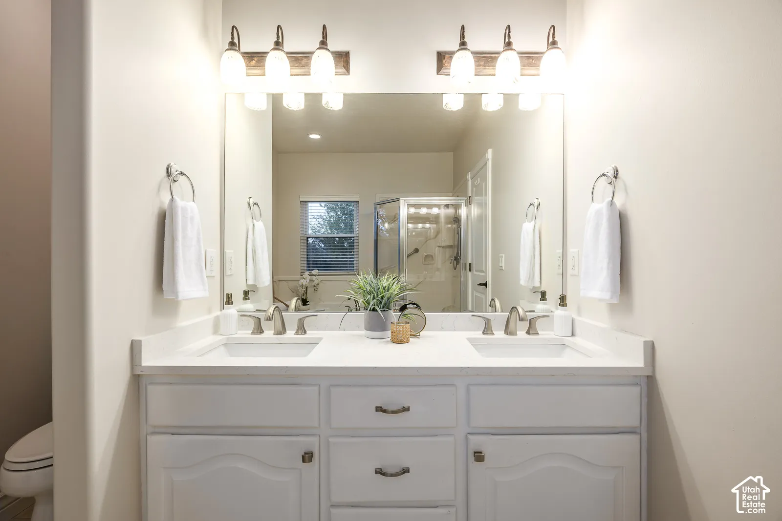 Double vanity with white cabinetry, dual undermount sinks, and brushed nickel fixtures