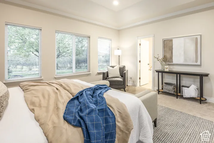 Recessed ceiling lighting, crown molding, multiple windows, carpet flooring, and a built-in console table