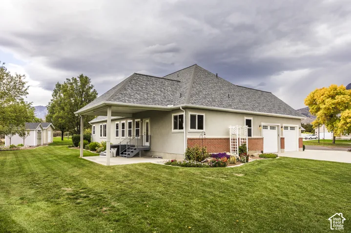 Expansive rear yard with a covered patio and concrete steps