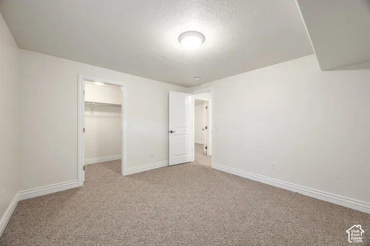 Carpeted room with white walls, white trim, and a flush mount ceiling light