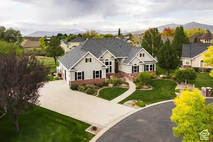 Two-story residence featuring light-colored stucco and brick veneer siding