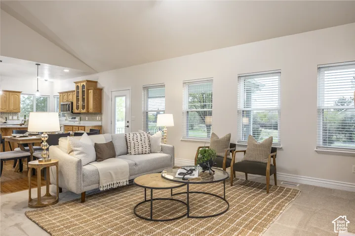 Vaulted ceilings enhance the living space, complemented by multiple windows with blinds