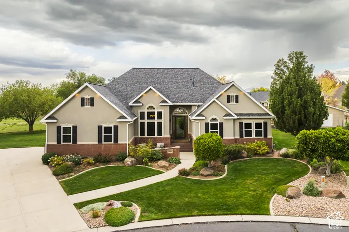 Stucco and brick exterior with a gray shingle roof