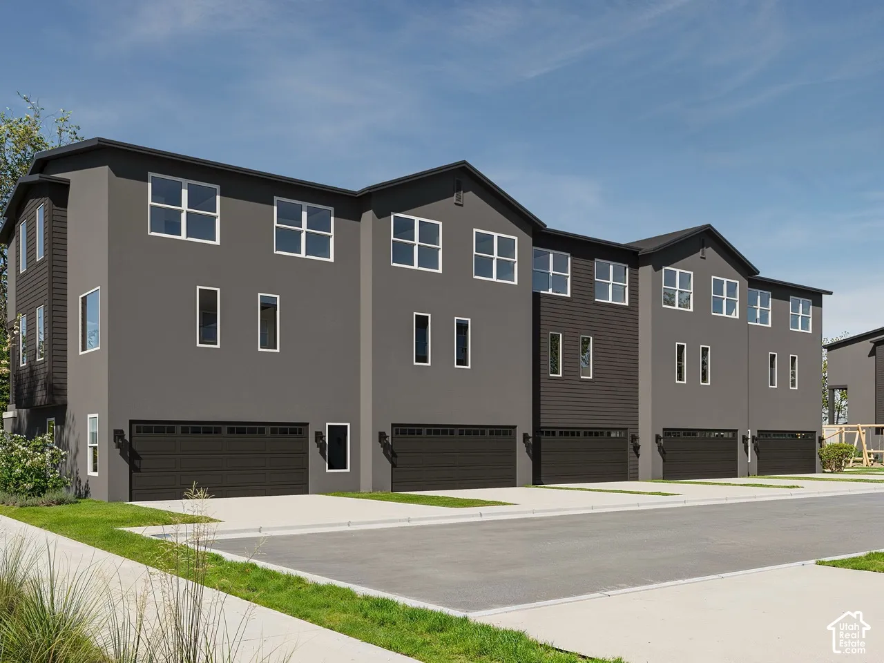Modern townhome architecture featuring dark siding and stucco finishes