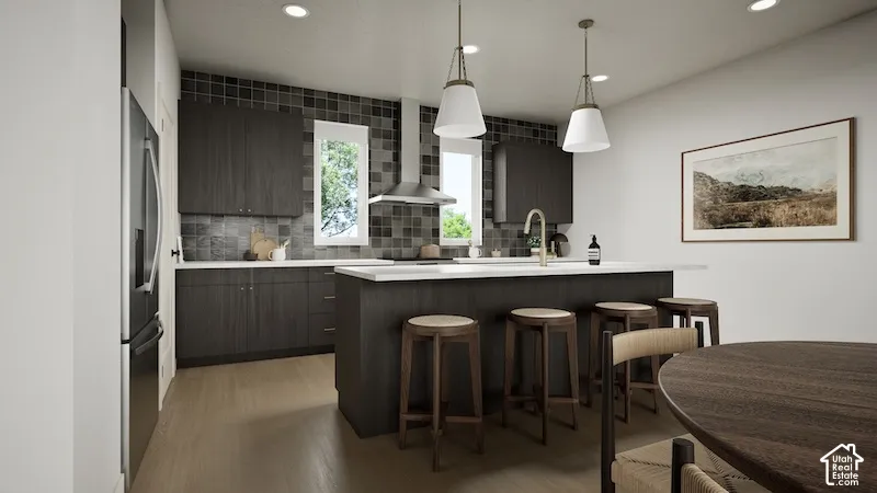 Kitchen featuring dark wood-finish cabinetry, stainless steel appliances, a center island with seating, pendant lighting, and recessed ceiling lights