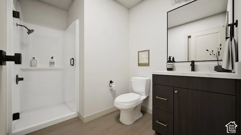 Shower with dark-toned fixtures, modern vanity with a rectangular sink, dark-toned cabinet with brass hardware, and light-toned flooring