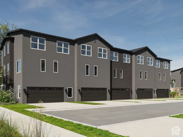 Modern townhome architecture featuring dark siding and stucco finishes