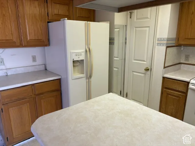 Lots of counterspace and a white fridge with an icemaker