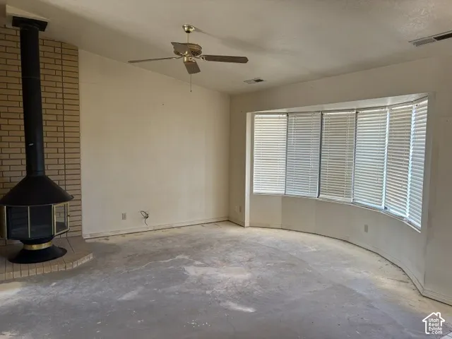 Freestanding fireplace with a brick surround and vaulted ceiling