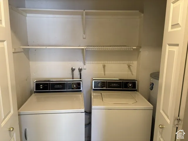 Dedicated laundry closet with built-in shelving, a full-size washer, and a full-size dryer