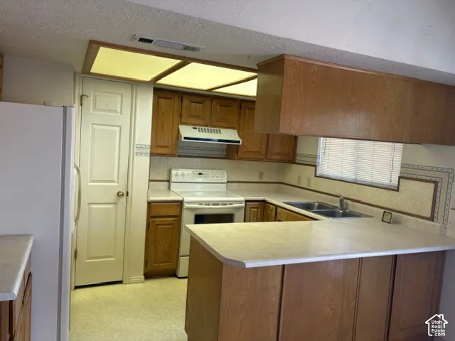 Overhead lighting, pantry, smooth-top range, white appliances and a breakfast bar