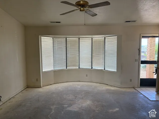Ceiling fan fixture and large bay window with blinds