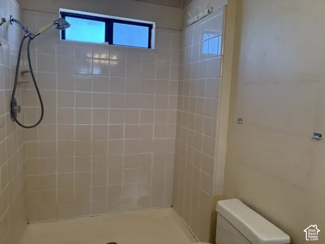 Tiled shower enclosure with an integrated window, featuring a wall-mounted shower head