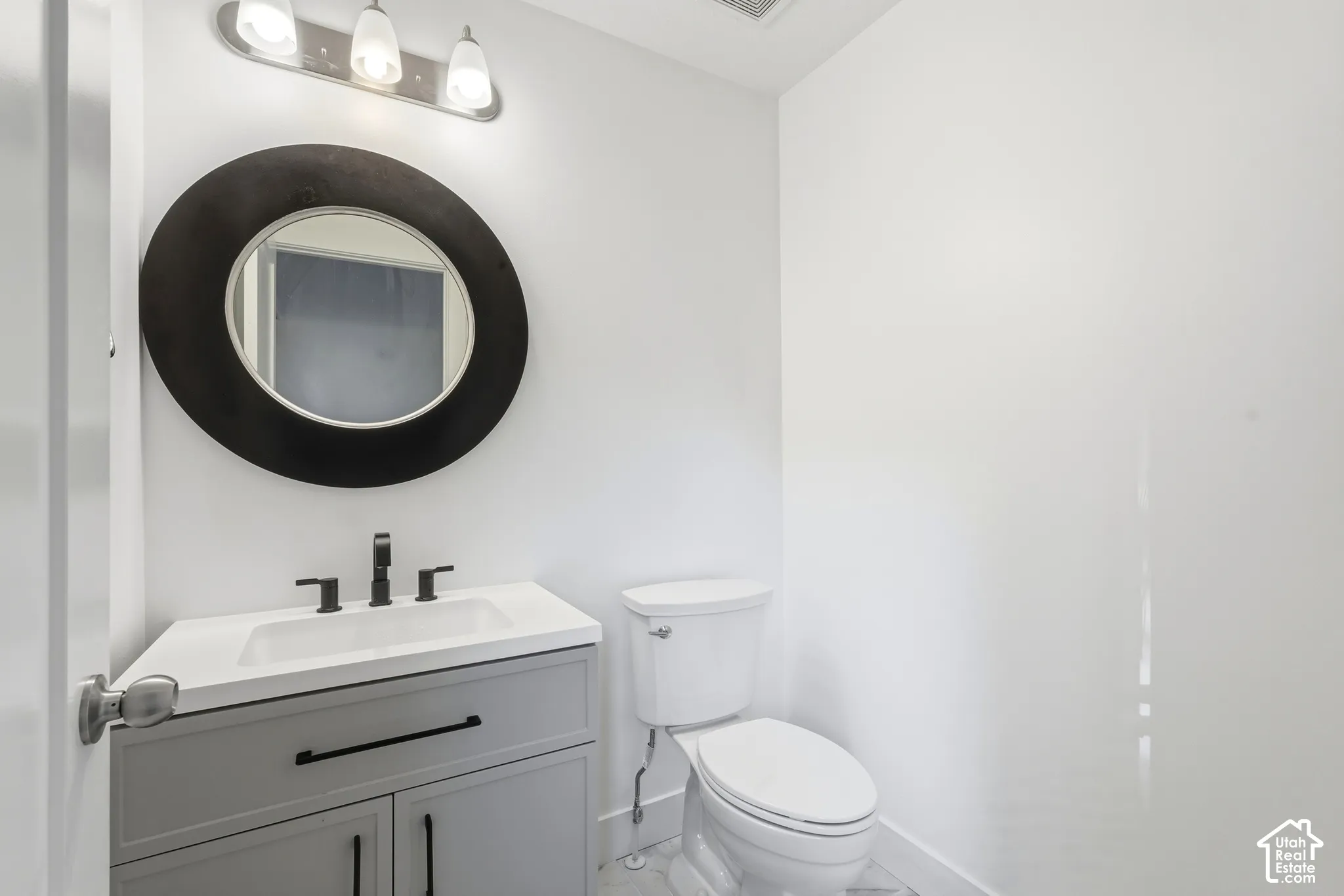 Vanity with integrated sink, matte black faucet, and gray cabinetry