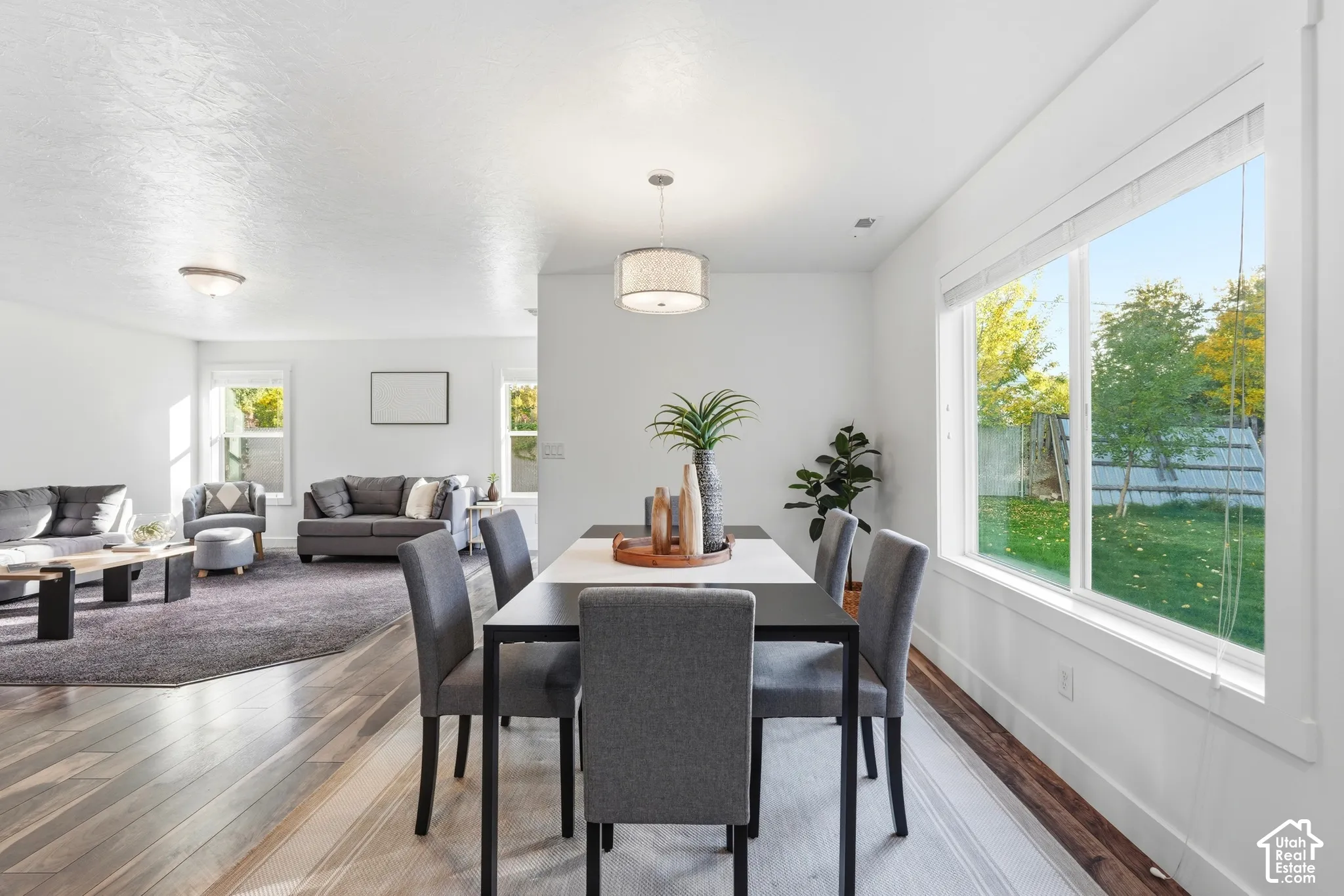Open-concept living area with wood-finish flooring, recessed lighting, and large windows providing abundant natural light