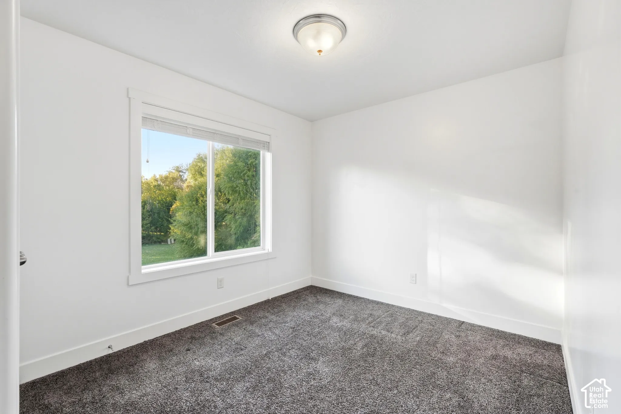 White walls with a single window and recessed lighting
