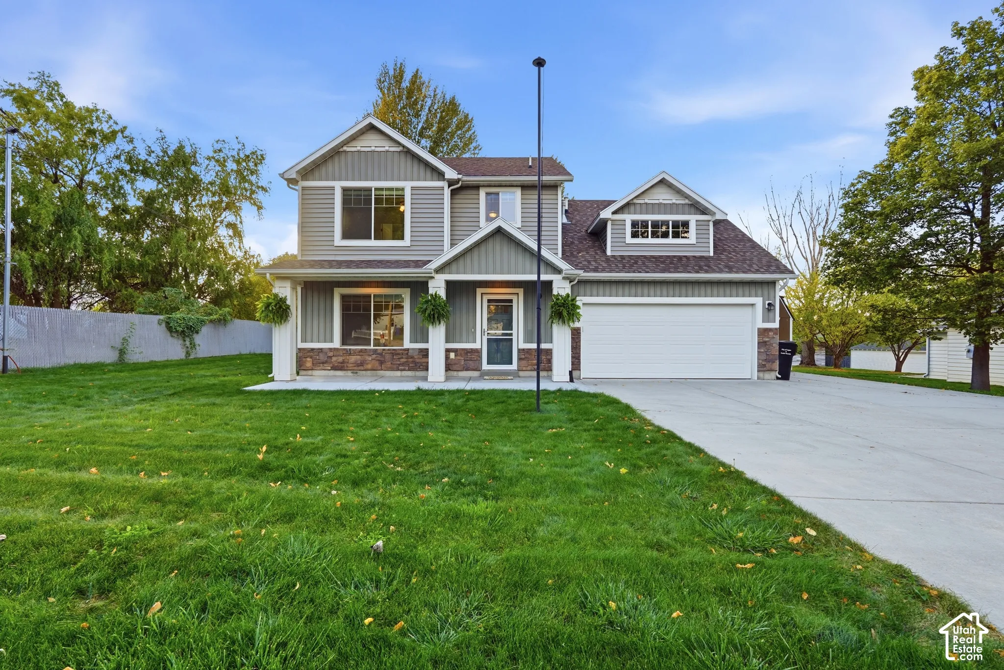 Two-story home with a two-car garage, concrete driveway, stone accents, and a covered entry