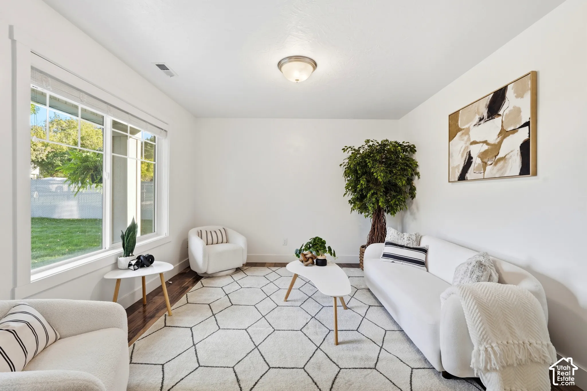 Expansive window providing ample natural illumination, wood-finish flooring, and recessed ceiling light fixture