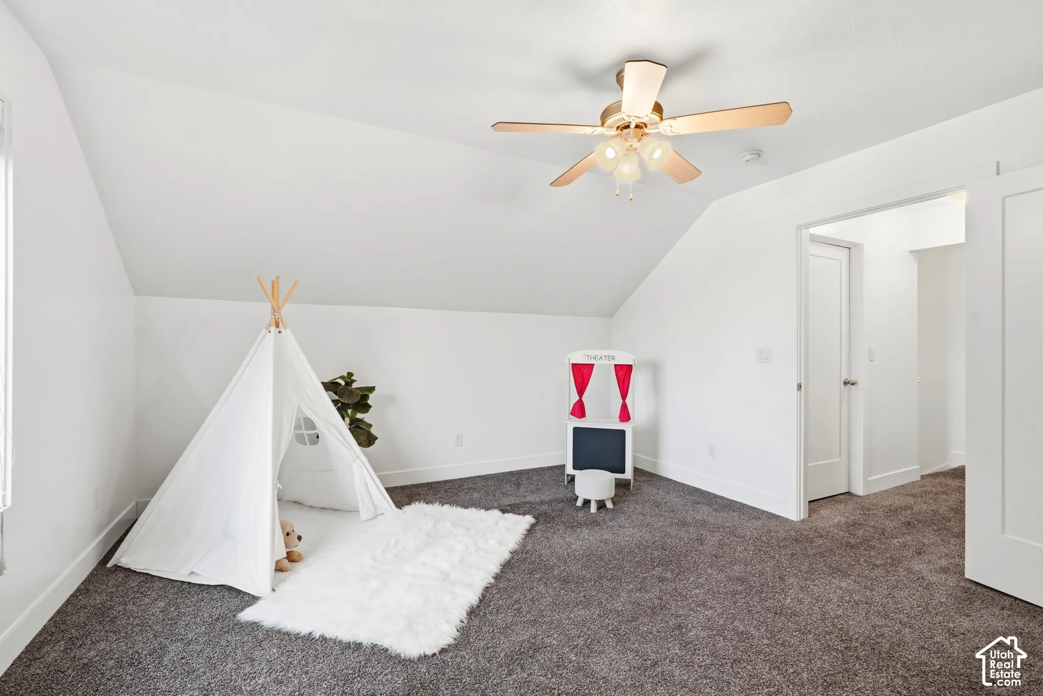 Sloped ceilings with a ceiling fan, light gray carpeting, and white walls