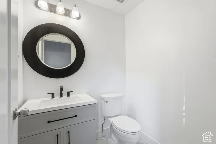 Vanity with integrated sink, matte black faucet, and gray cabinetry