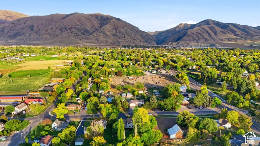 Expansive community bordered by mountainous terrain, featuring abundant mature trees and residential properties