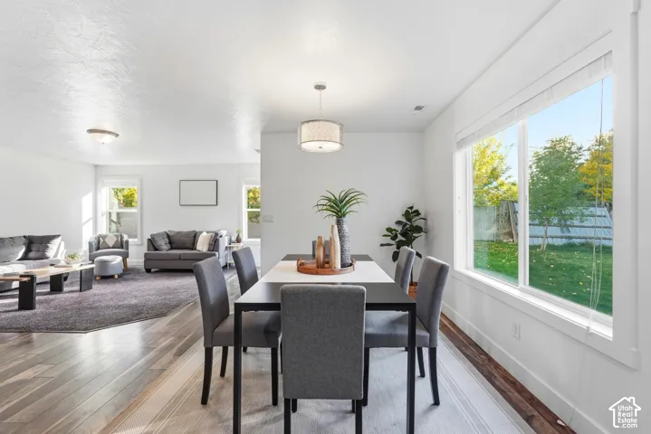 Open-concept living area with wood-finish flooring, recessed lighting, and large windows providing abundant natural light