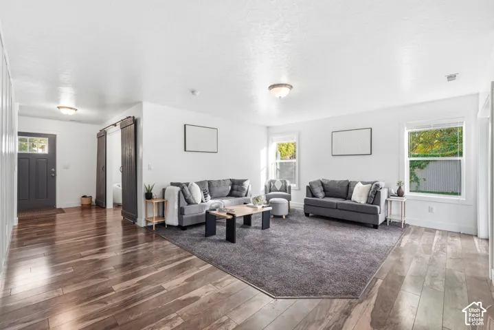 Spacious living area featuring wood-finish flooring, recessed lighting, and white walls