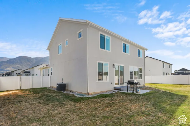 Stucco exterior with multiple windows, leading to a concrete patio