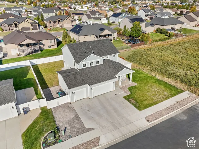 Light gray exterior with white trim, a covered porch, a two-car garage, and a concrete driveway