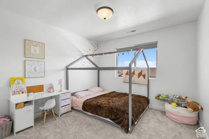 White walls with a single window, overhead lighting, and carpeted flooring