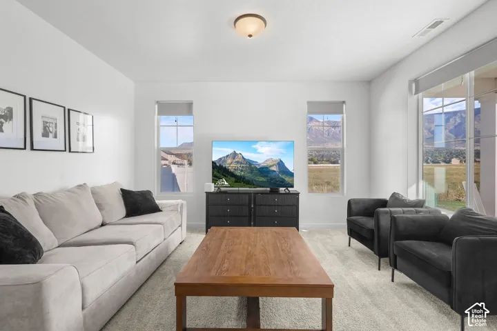 Neutral wall paint, carpeted flooring, recessed lighting, and ample natural light through large windows
