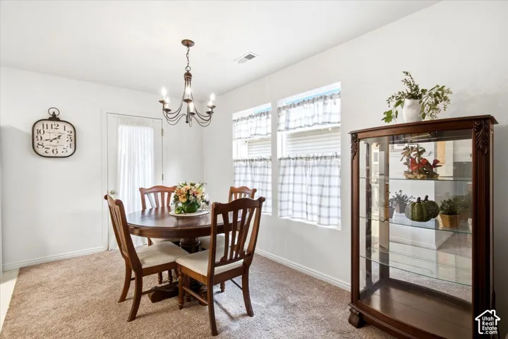 Recessed lighting, warm-toned carpeting, and a traditional chandelier