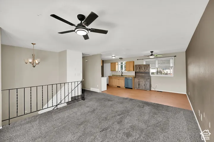 Open-concept living space with gray carpeting and a neutral color palette