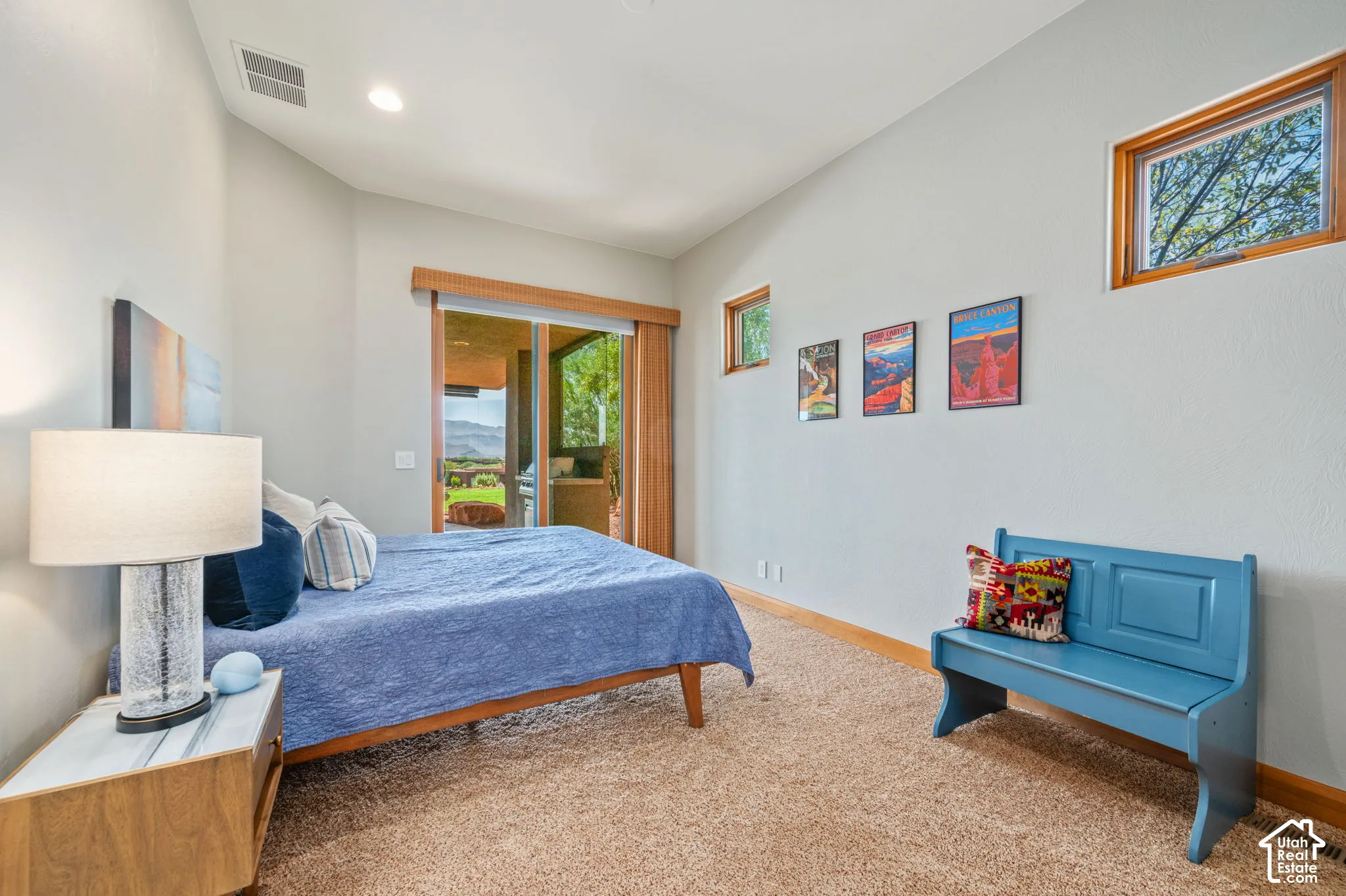 Carpeted bedroom with a sliding glass door, recessed lighting, and wood-framed windows