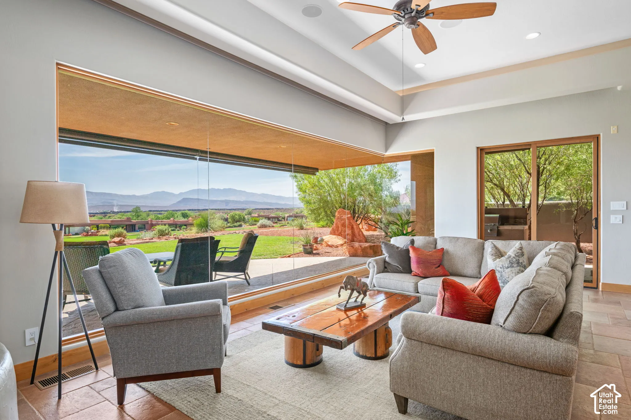 Expansive floor-to-ceiling windows, tray ceiling, recessed lighting, ceiling fan, and tile flooring