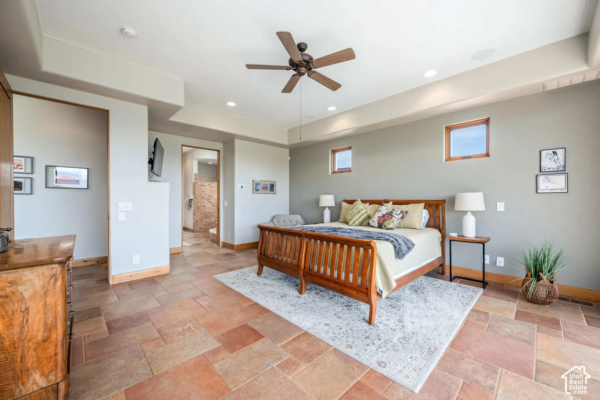 Expansive room featuring large format tile flooring, recessed ceiling lighting, a ceiling fan, and multiple windows