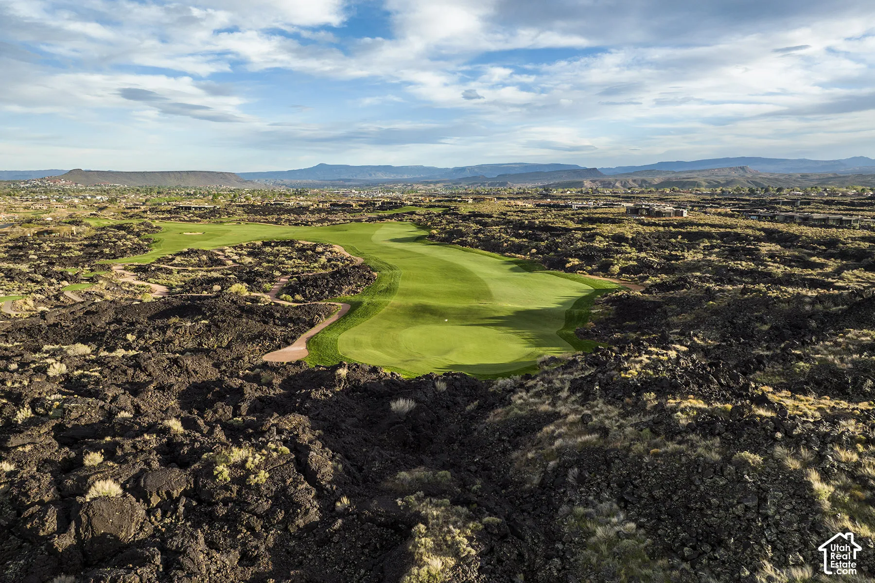 Expansive golf course green set amidst a natural volcanic rock landscape